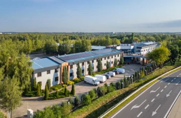Hotel 500 Stryków otoczony zielenią, widok z lotu ptaka na budynek hotelu i drogę dojazdową.
